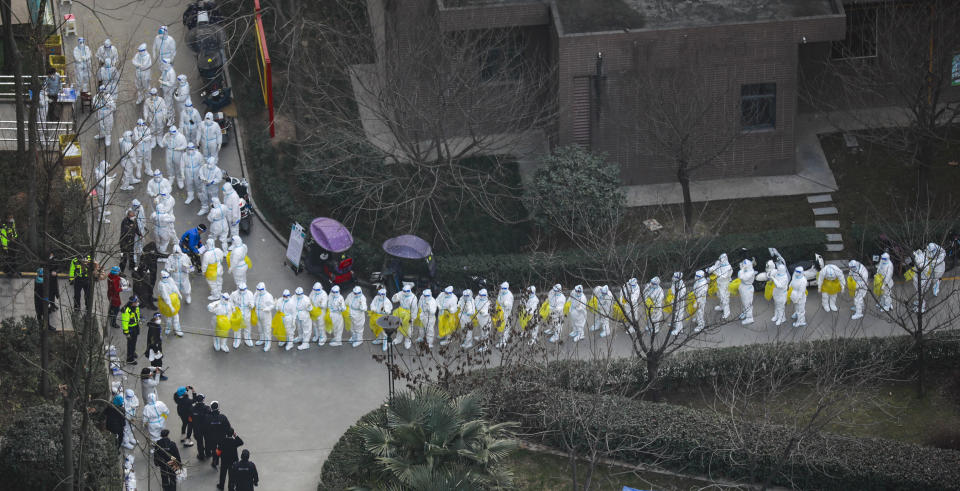 A long line of health workers prepare to collect swab samples during a Covid-19 testing operation at a residential block on January 3, 2022 in Xi an.