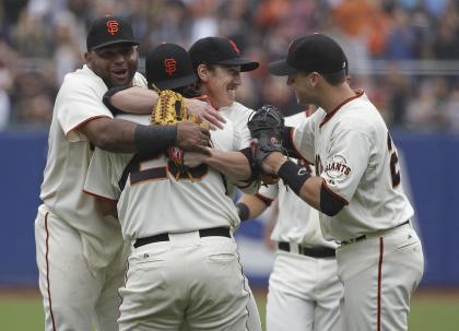 Tim Lincecum, center, is embraced by teammates, from left, Pablo Sandoval, catcher Hector Sanchez, and Buster Posey. (AP)