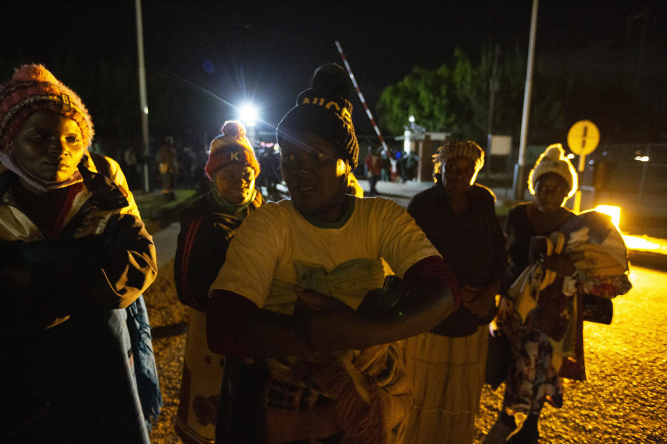 Tobacco growers are seen outside auction floors at night in Harare, Wednesday, April 14, 2021. Zimbabwe’s tobacco is flourishing again. And so are the auctions where merchants are fetching premium prices for the “golden leaf” that is exported around the world. Many of the small-scale farmers complain they are being impoverished by middlemen merchants who are luring them into a debt trap. (AP Photo/Tsvangirayi Mukwazhi)