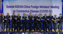 Chinese Foreign Minister Wang Yi, sixth from left, poses for a group photo with from left, Malaysian Foreign Minister Saifuddin Abdullah, Myanmar Minister of State for Foreign Affaires Kyaw Tin, Singapore's Foreign Minister Vivian Balakrishnan, Thailand's Foreign Minister Don Pramudwinai, Vietnamese Foreign Minister Pham Binh Minh, Philippines Foreign Affaires Secretary Teodoro Locsin Jr., Laos Foreign Minister Saleumxay Kommasith, Brunei Second Minister of Foreign Affairs and Trade Erywan Yusof, Cambodian Foreign Minister Prak Sokhon, Indonesian Foreign Minister Retno Marsudi, and ASEAN Secretary General Dato Lim Jock Hoi ahead of the Special ASEAN-China Foreign Ministers' meeting on the Novel Coronavirus Pneumonia in Vientiane, Laos, Thursday, Feb. 20, 2020. (AP Photo/Sakchai Lalit)