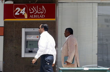 Men walk pass an automated teller machine (ATM) Bank Albilad in Riyadh, Saudi Arabia, April 25, 2016. REUTERS/Faisal Al Nasser