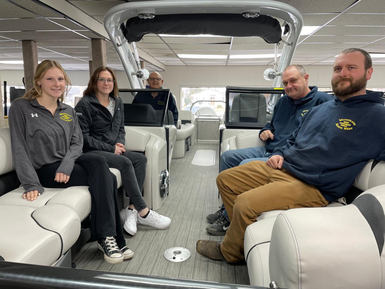 From left, Ellie, Maggie, Gary, Paul and Jordan Mitter sit in an Avalon Excalibur pontoon boat in Wonderland Marine West's current showroom in Genoa Township, Wednesday, March 29, 2023.