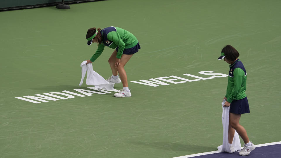 Water is wiped off the court during a rain delay of a match between Cameron Norrie, of Britain, and Frances Tiafoe, of the United States, at the BNP Paribas Open tennis tournament Wednesday, March 15, 2023, in Indian Wells, Calif. (AP Photo/Mark J. Terrill)