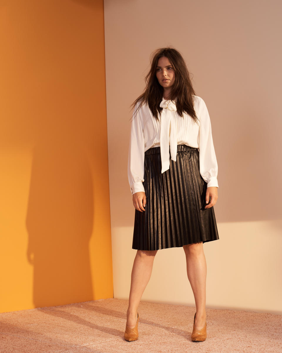 Candice Huffine wears a cream blouse and pleated black skirt from the new Prabal Gurung x Lane Bryant collection. (Photo: Courtesy of Lane Bryant)