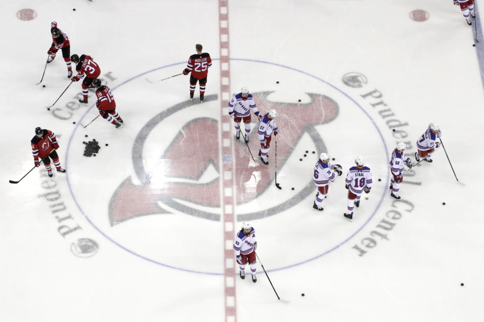 FILE - In this April 1, 2019, file photo, New Jersey Devils, left, and New York Rangers warm up for an NHL hockey game in Newark, N.J. Deputy Commissioner Bill Daly told The Associated Press on Sunday, July 5, 2020, that the NHL and NHL Players’ Association have agreed on protocols to resume the season. Daly said the sides are still negotiating a collective bargaining agreement extension. A CBA extension is still crucial to the process. (AP Photo/Julio Cortez, File)