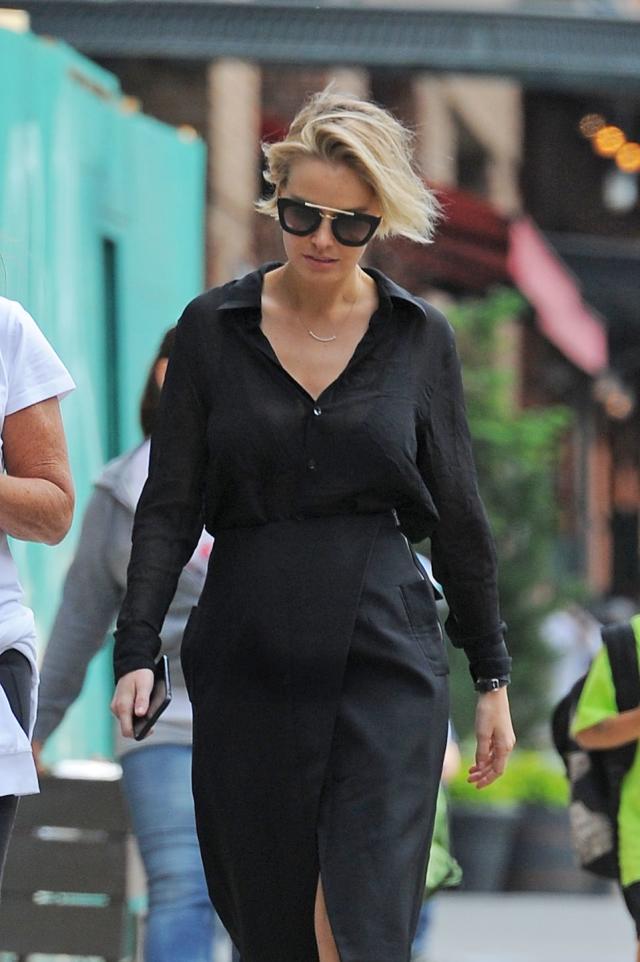 Pregnant Lara Bingle covers up her baby bump in a winter coat in