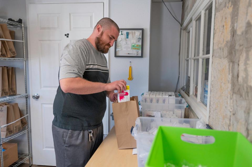 Brandon Porter, health hub peer navigator for Access Point Pueblo, fills bags with supplies for individual client needs on Tuesday, April 16, 2024.