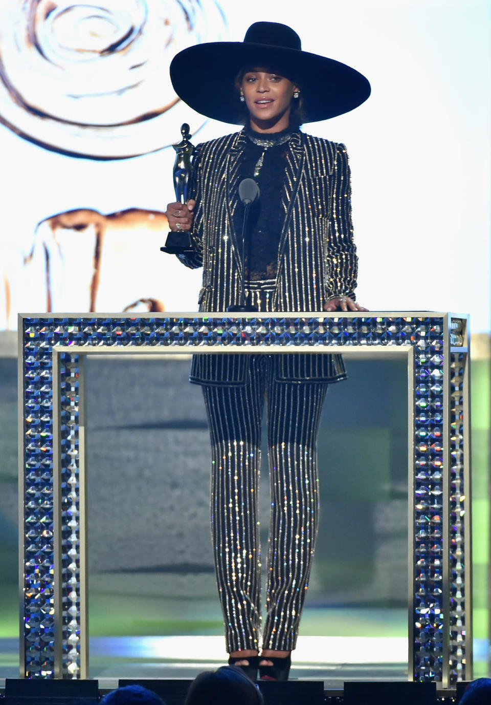 Beyoncé wearing a sequin-striped suit from Givenchy with an oversized hat 