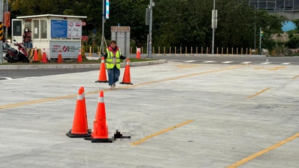 管理人員擺放三角錐，避免車輛再次輾過小黑狗的屍體。（圖／民眾提供）