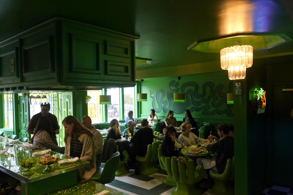 Diners sit at tables and the bar at Shuggie's Trash Pie restaurant in San Francisco, Wednesday, June 14, 2023. World Upcycling Day is June 24, celebrating the repurposing of old products into something new. This year, the movement is focusing on upcycling food, like misshapen produce or offcuts of meat, as a way to prevent food waste. (AP Photo/Jeff Chiu)