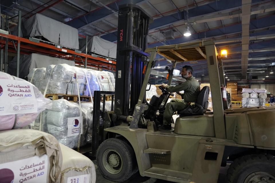 A forklift driver loads assistance packages to be sent for earthquake hit areas of Turkey, at Al-Udeid Air Base in Doha, Qatar, Tuesday, Feb. 7, 2023. (AP Photo/Kamran Jebreili)