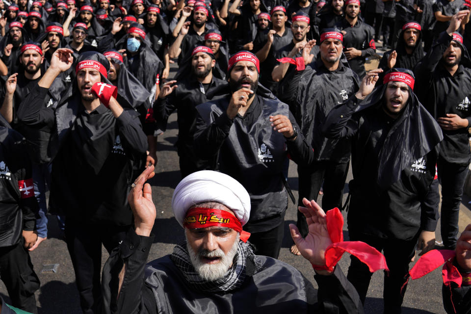 Lebanese Shiite supporters of Iranian-backed Hezbollah group, beat their chests as they march during the Shiite Muslim holy day of Ashoura that commemorates the 7th century martyrdom of the Prophet Muhammad's grandson Hussein, in the southern suburb of Beirut, Lebanon, Tuesday, Aug. 9, 2022. The leader of Lebanon's Hezbollah group Sheikh Hassan Nasrallah warned archenemy Israel on Tuesday over the two countries' maritime border dispute. (AP Photo/Hussein Malla)