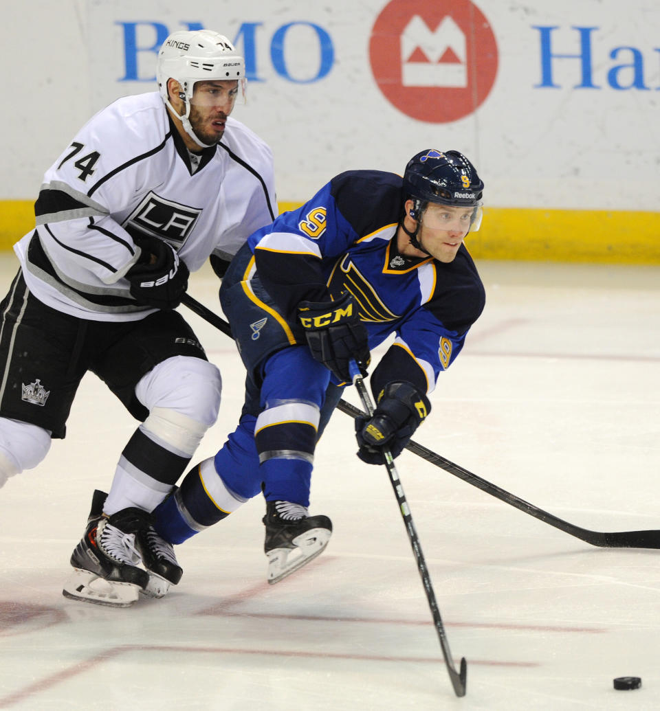 St. Louis Blues' Jaden Schwartz (9) passes in front of Los Angeles Kings' Dwight King (74) during the second period of an NHL hockey game on Thursday, Jan. 2, 2014 in St. Louis. (AP Photo/Bill Boyce)