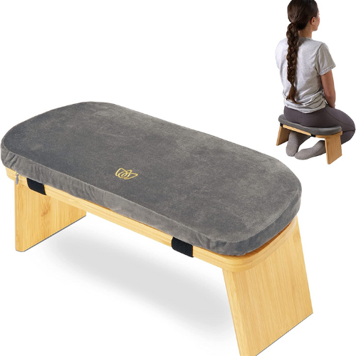 gray cushion and light wood meditation bench and a woman kneeling and using the bench