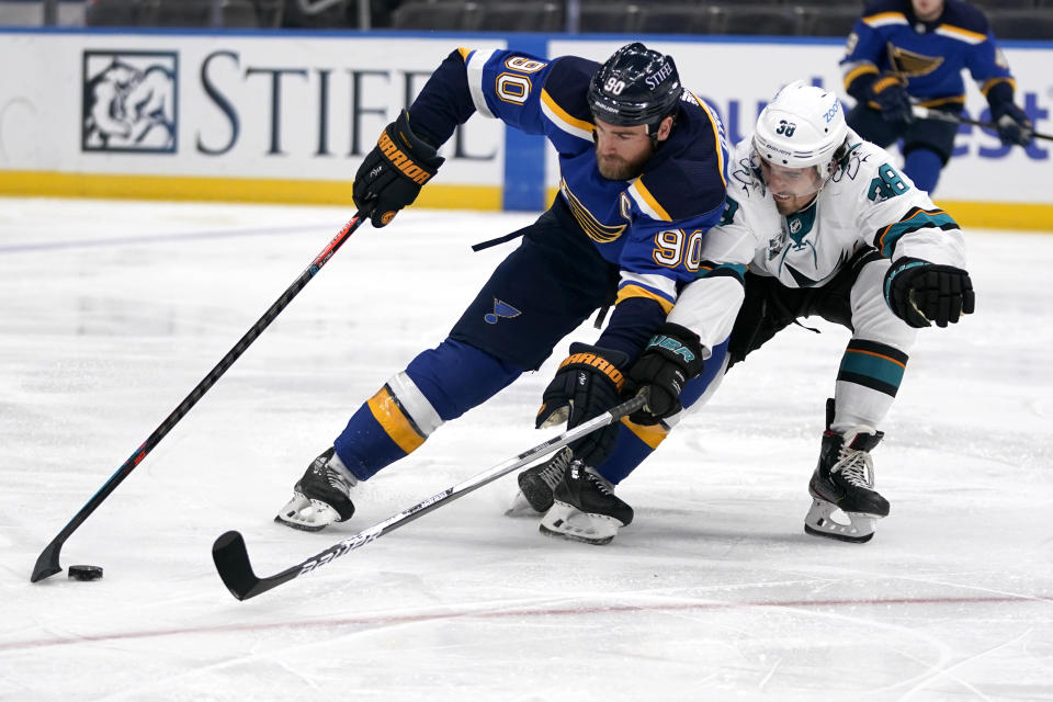 St. Louis Blues' Ryan O'Reilly (90) and San Jose Sharks' Mario Ferraro (38) reach for a loose puck during the second period of an NHL hockey game Thursday, Feb. 18, 2021, in St. Louis. (AP Photo/Jeff Roberson)