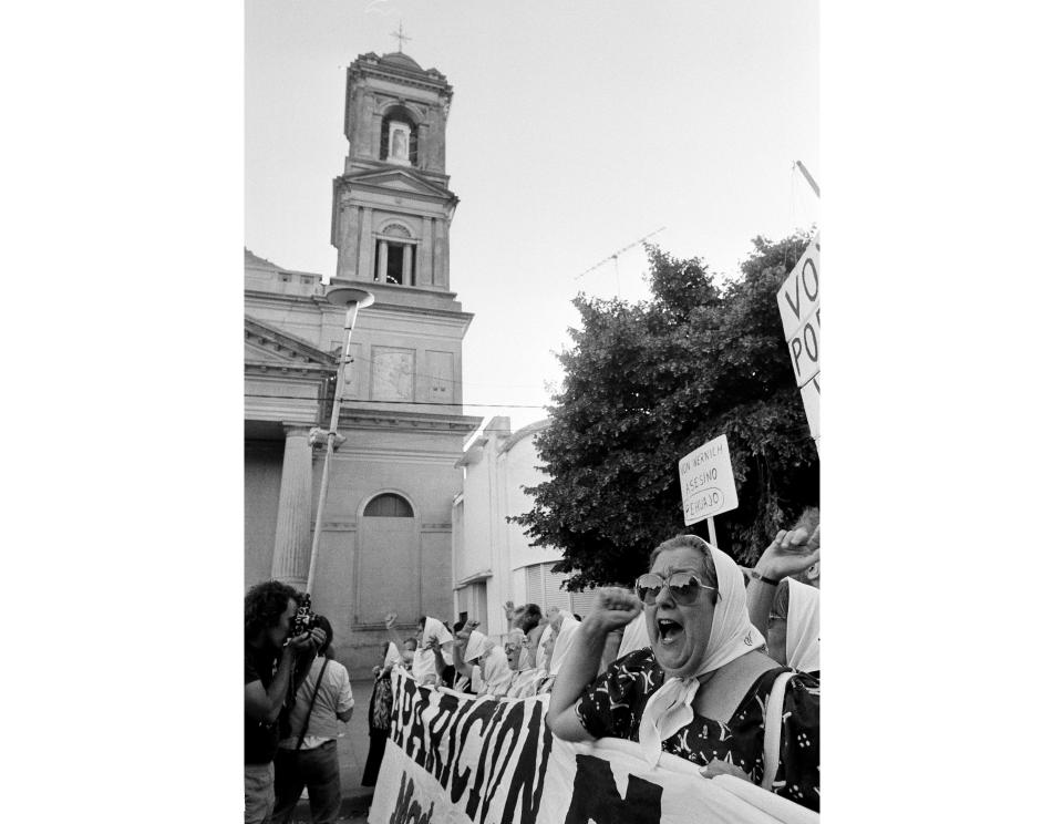 Leader of the human rights group Mothers of Plaza de Mayo, Hebe de Bonafini, right, leads a protest outside a church where former police chaplain Christian Von Wernich offered a mass in Bragado, Argentina, Nov. 28, 1988. Hebe de Bonafini, who became a famed human rights campaigner after her two children were arrested and disappeared under Argentina's military dictatorship, died Sunday, Nov. 20, 2022, her family and authorities reported. She was 93. (AP Photo/Eduardo Di Baia)