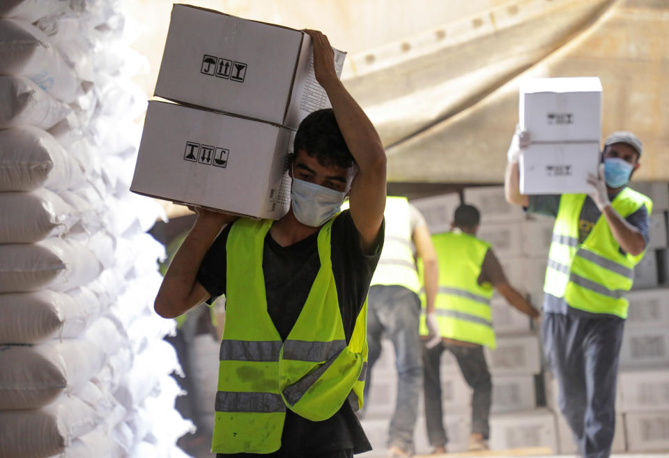 Image: Workers carry boxes of humanitarian aid near Bab al-Hawa crossing at the Syrian-Turkish border. (Mahmoud Hassano / Reuters)