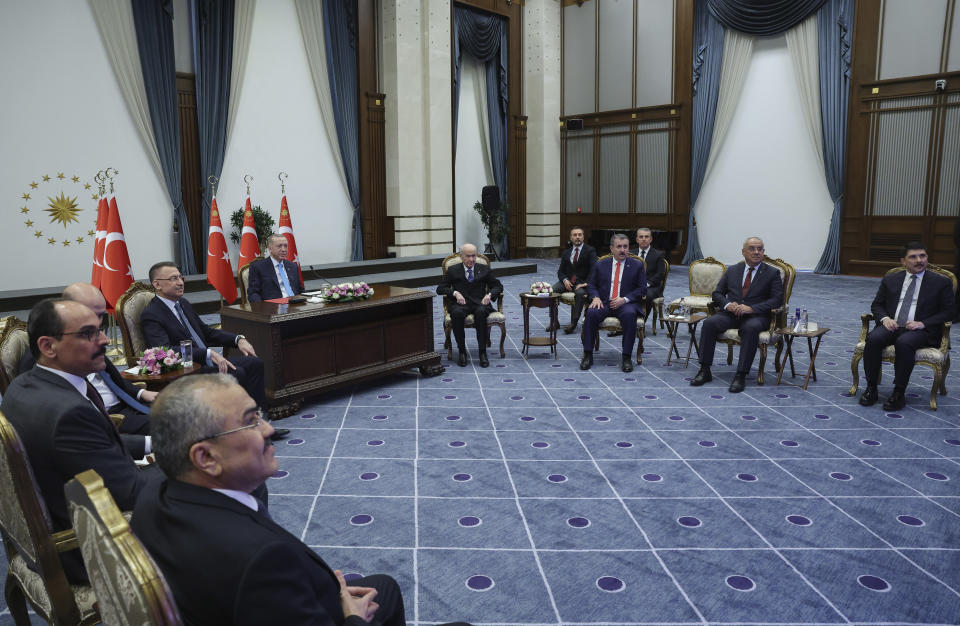 In this handout photo released by Turkish Presidency, Turkey's President Recep Tayyip Erdogan, left, inaugurates Turkey's first nuclear power plant via a video link, at the Presidential palace in Ankara, Thursday, April 27, 2023. Sitting behind a desk surrounded by Cabinet members, aides and political allies, the 69-year-old leader remotely presided over the event marking the delivery of the first fuel to Russian-built Akkuyu Nuclear Power Plant, in southern Turkey. (Turkish Presidency via AP)