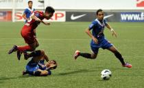 Singapore's LionsXII player Nazrul Nazari (L) leaps over KL Felda United player Mohd Akmal at the Jalan Besar Stadium during the Malaysian Super League in Singapore on July, 2 2013. The LionsXII clinched the Malaysian Super League title Tuesday with a clinical 4-0 win over minnows Felda United, rekindling the city-state's glory days in the competition after a nearly two-decade absence