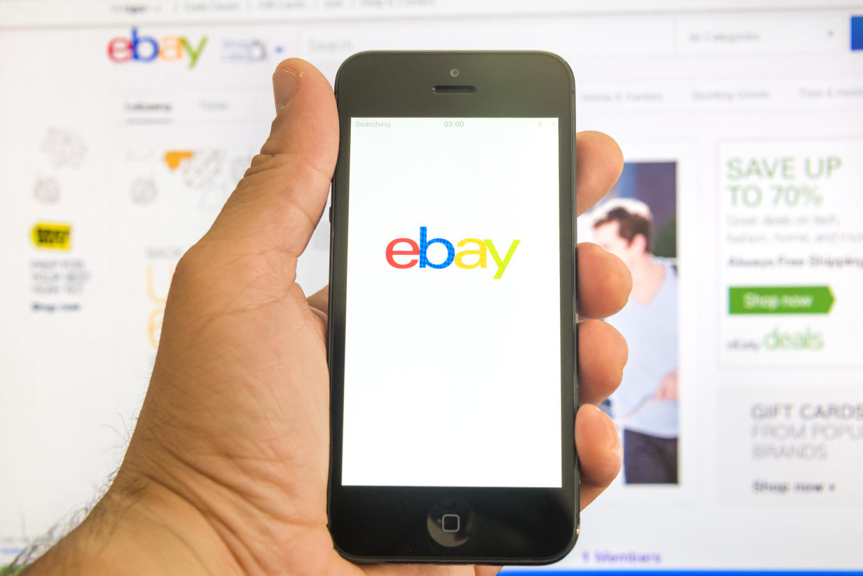 New York, U.S.A. - August 13, 2015: Ebay home page on the screen of a iphone 5 smart phone and in browser window in the background. eBay is the most visited an online auction and shopping website in US.