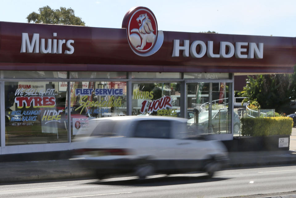 FILE - In this Dec. 11, 2013, file photo, a car drives past a car dealership of Holden, General Motors Co.'s Australian subsidiary, in Sydney, Australia. General Motors decision to pull out of Australia, New Zealand and Thailand as part of a strategy to exit markets that don't produce adequate returns on investments raised dismay Monday, Feb. 17, 2020 from officials concerned over job losses. (AP Photo/Rob Griffith, File)