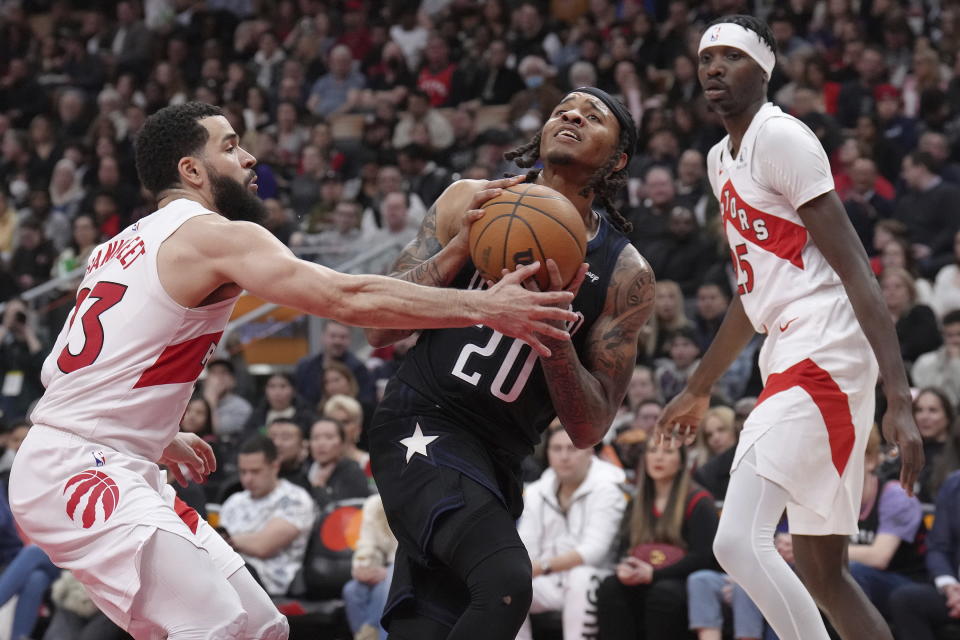 Orlando Magic's Markelle Fultz looks to shoot on Toronto Raptors' Fred VanVleet (left) as Raptors' Chris Boucher looks on during the second half of an NBA basketball game in Toronto on Tuesday, Feb. 14, 2023. (Chris Young/The Canadian Press via AP)