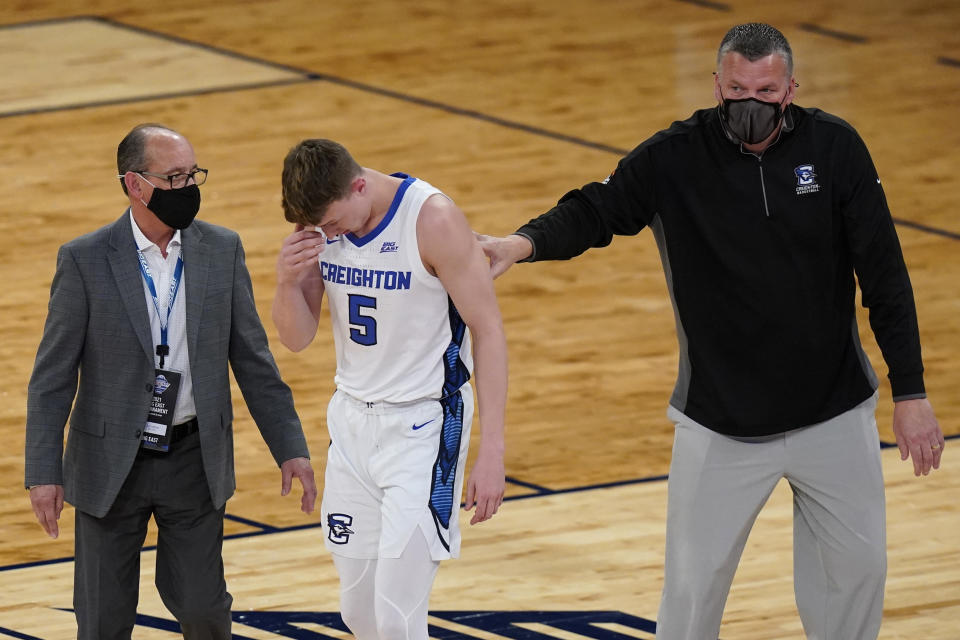 Creighton coach Greg McDermott, right, and a trainer check on Alex O'Connell (5) after O'Connell was hurt during the first half of the team's NCAA college basketball game against Butler in the Big East men's tournament Thursday, March 11, 2021, in New York. (AP Photo/Frank Franklin II)