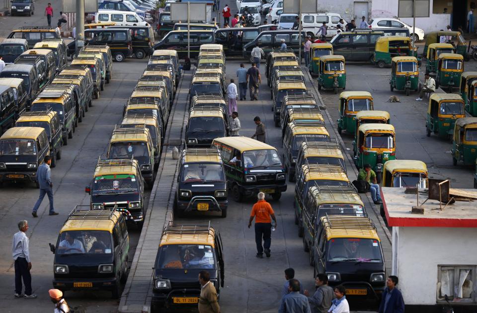 In this Monday, March 24, 2014 photo, traditional black-and-yellow licensed cabs stand parked waiting for customers at a railway station in New Delhi, India. Most licensed taxis are banned from having air conditioning under an archaic municipal rule, leaving passengers suffering with rolled-down windows in suffocating heat and noxious pollution. Taxi-hailing smartphone app Uber is making a big push into Asia with the company starting operations in 18 cities in Asia and the South Pacific including Seoul, Shanghai, Bangkok, Hong Kong and five Indian cities in the last year. (AP Photo/Saurabh Das)