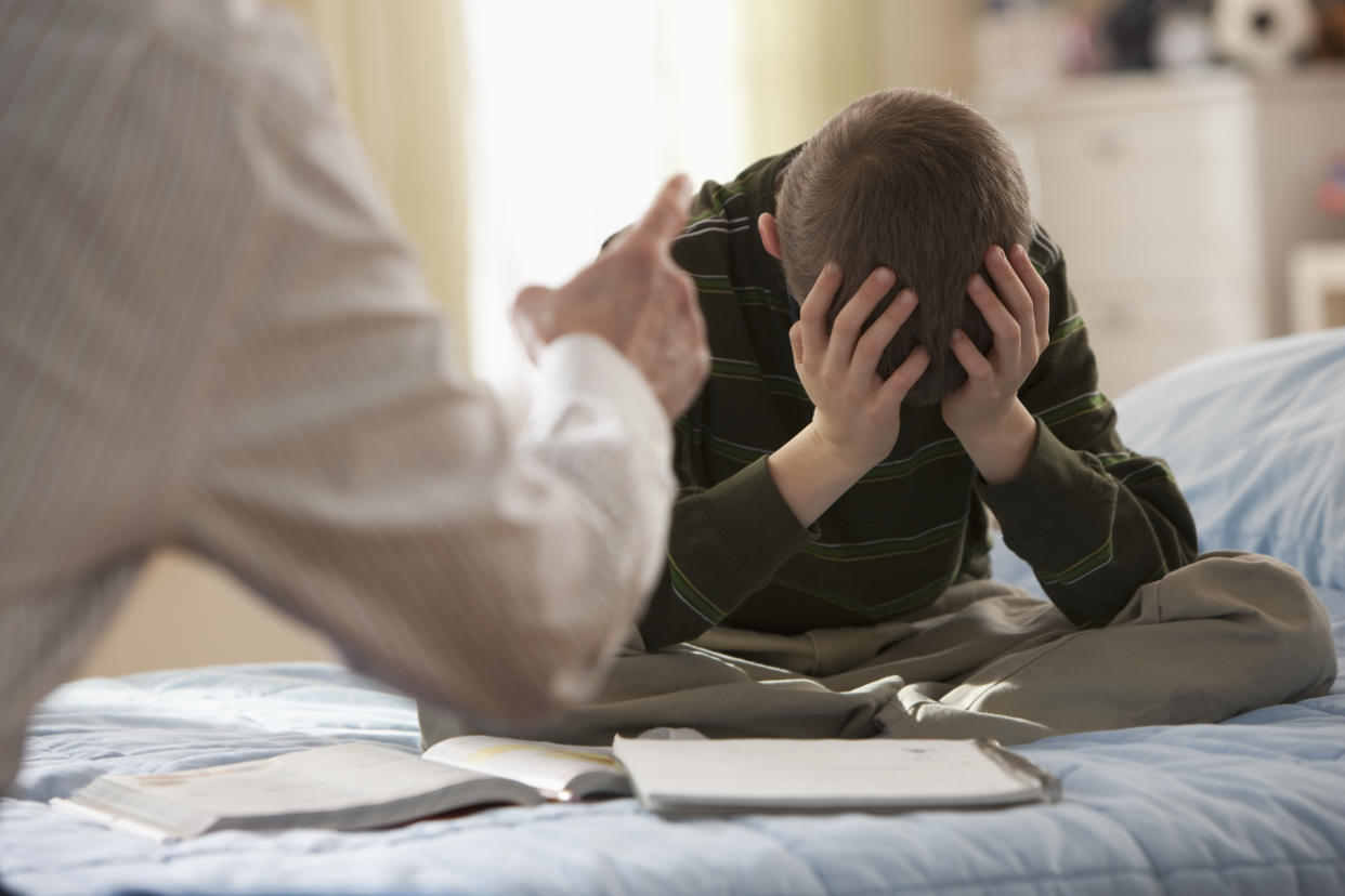 Boy with head in his hands being punished discipline