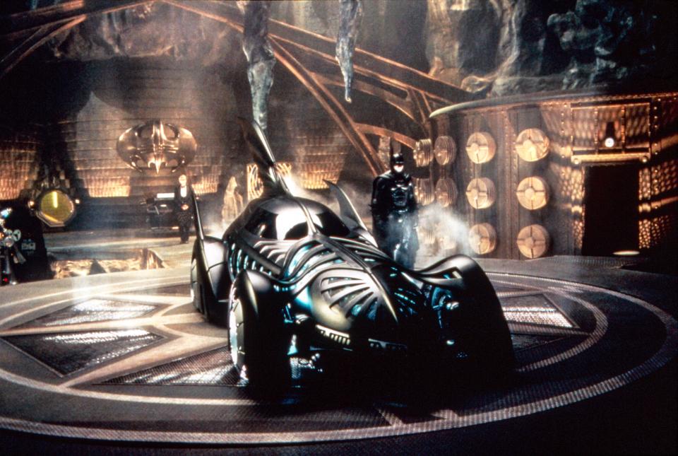 Batman (Val Kilmer) strikes a pose in the Batcave next to the Batmobile in 'Batman Forever' (Photo: Warner Bros./courtesy Everett Collection)