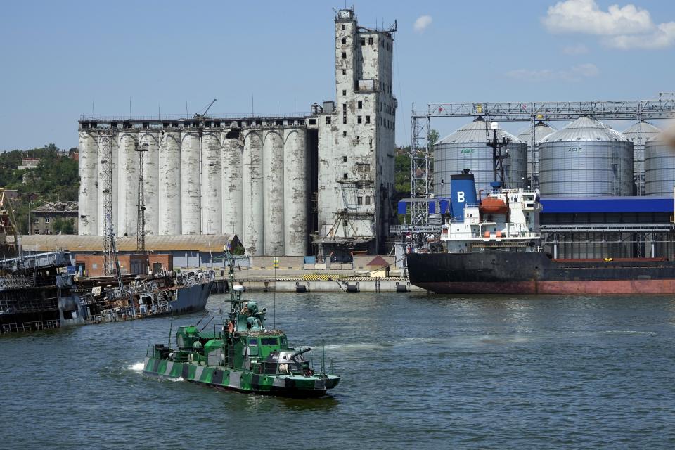 FILE - A Russian military boat guards an area with the grain storage in the background at the Mariupol Sea Port which has recently started its work after heavy fighting in Mariupol, on the territory which is under the Government of the Donetsk People's Republic control, eastern Ukraine, June 12, 2022. According to Russian state TV, the future of the Ukrainian regions occupied by Moscow's forces is all but decided: Referendums on becoming part of Russia will soon take place there, and the joyful residents who were abandoned by Kyiv will be able to prosper in peace. In reality, the Kremlin appears to be in no rush to seal the deal on Ukraine's southern regions of Kherson and Zaporizhzhia and the eastern provinces of Donetsk and Luhansk. (AP Photo, File)