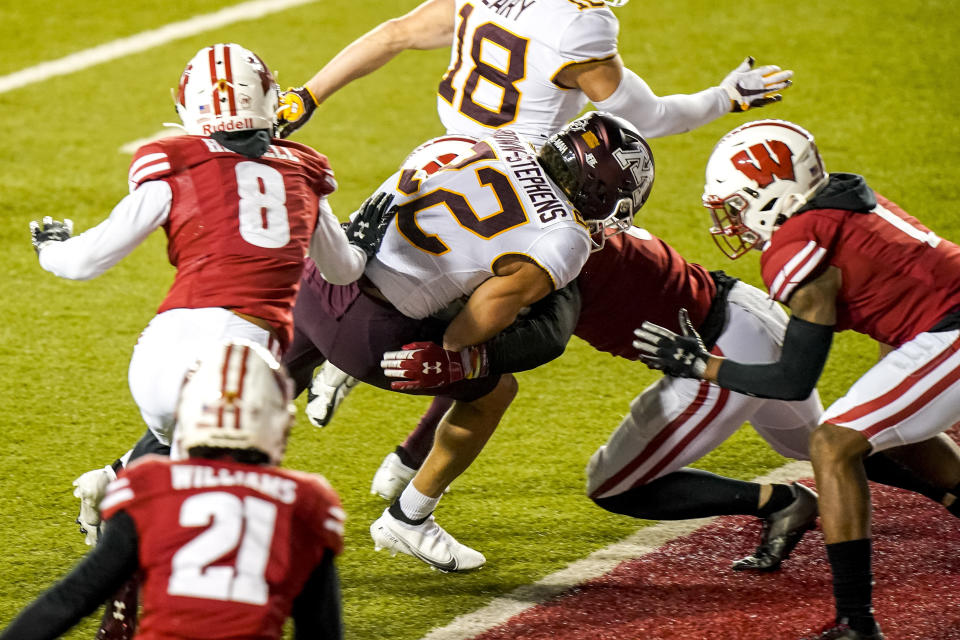 Minnesota wide receiver Mike Brown-Stephens (22) scores a touchdown against Wisconsin cornerback Deron Harrell (8), safety Scott Nelson, behind, and cornerback Faion Hicks (1) during the second half of an NCAA college football game Saturday, Dec. 19, 2020, in Madison, Wis. (AP Photo/Andy Manis)