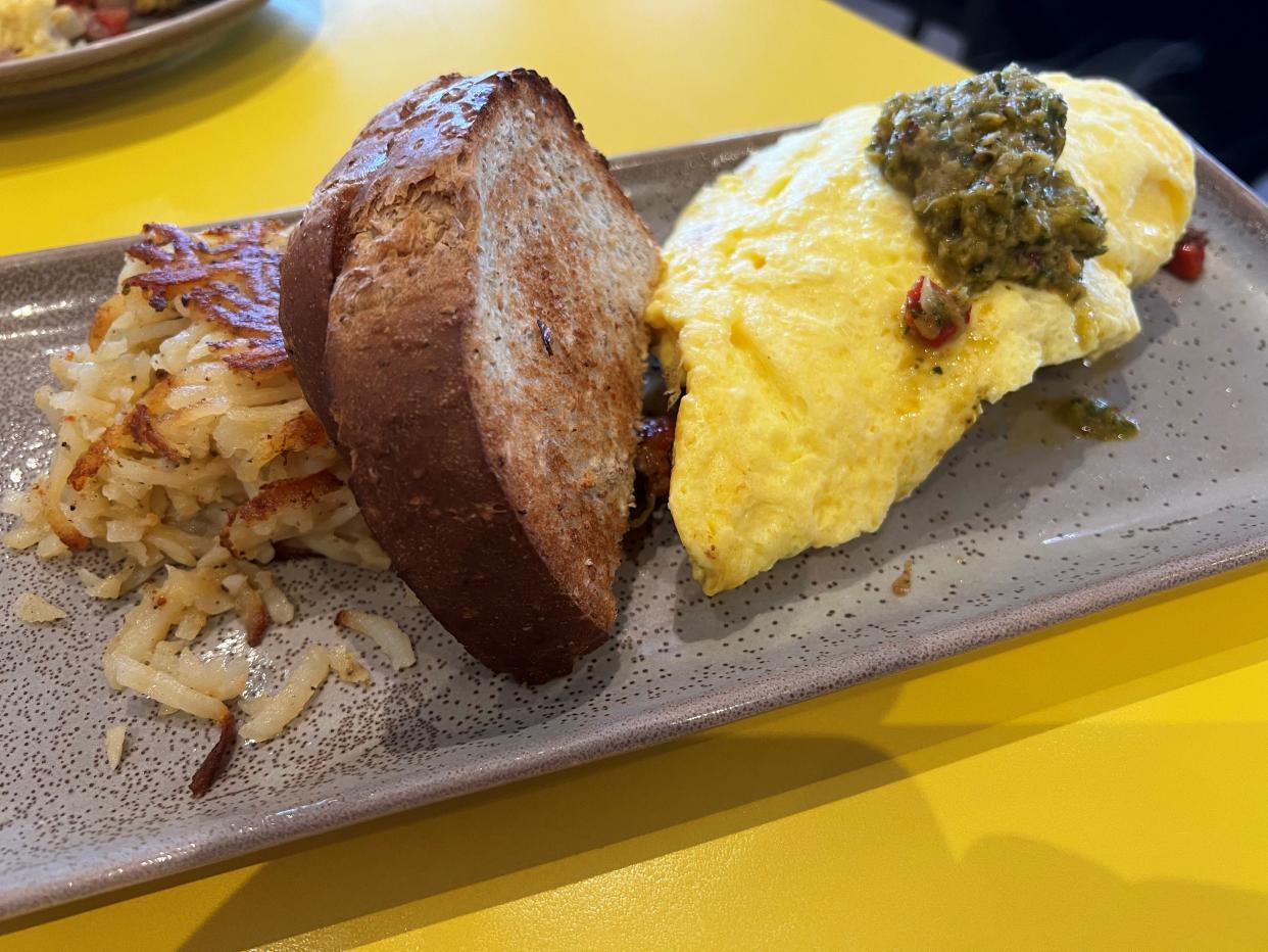 The Wide Awake omelet at Early Bird Brunch features steak, caramelized onions, roasted red peppers, house chimichurri, and Gouda with toast and hash browns.