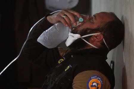 A civil defence member breathes through an oxygen mask, after what rescue workers described as a suspected gas attack in the town of Khan Sheikhoun in rebel-held Idlib, Syria April 4, 2017. REUTERS/Ammar Abdullah