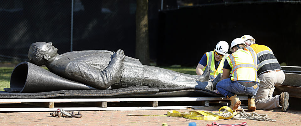 Workers secure the statue of Harry F. Byrd, Sr., former Virginia Governor and U. S. Senator, to a pallett after it was removed from the pedestal in Capitol Square in Richmond, Va. Wednesday, July 7, 2021. The General Assembly approved the removal during the last session. (Bob Brown/Richmond Times-Dispatch via AP)