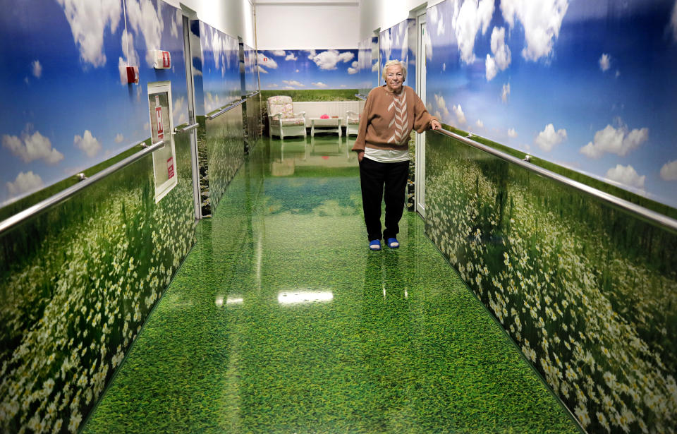 FILE- In this file photo dated Sunday, Oct. 20, 2019, an elderly woman stands in the corridor of a retirement home during a visit by Romanian presidential candidate for the ruling Social Democratic party (PSD) Viorica Dancila in Bucharest, Romania. Romania will hold presidential elections on Nov. 10. (AP Photo/Vadim Ghirda, File)