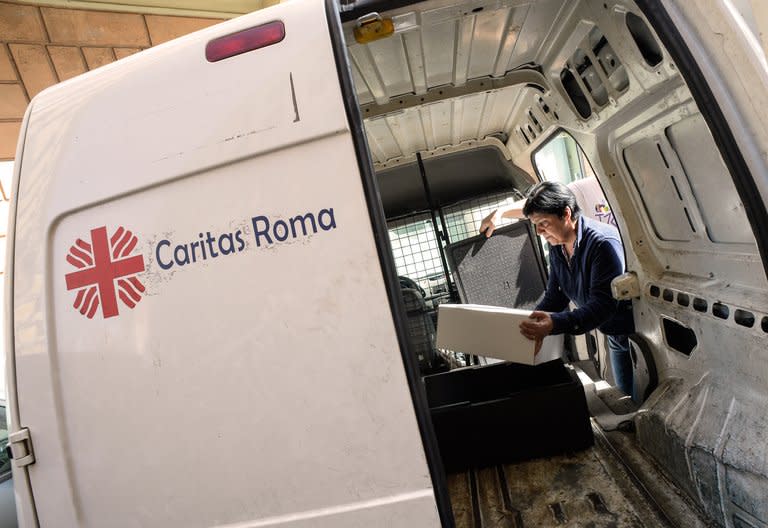A Caritas volunteer carries away boxes of food scraps from a Rome eaterie on May 28, 2013. The initiative began in Genoa in 2007 and is now also up and running in Florence. It plans to extend to Palermo in Sicily in the near future