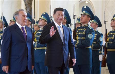 Kazakhstan's President Nursultan Nazarbayev (L) and his Chinese counterpart Xi Jinping walk past honor guards during an official welcoming ceremony in Astana September 7, 2013. REUTERS/Shamil Zhumatov