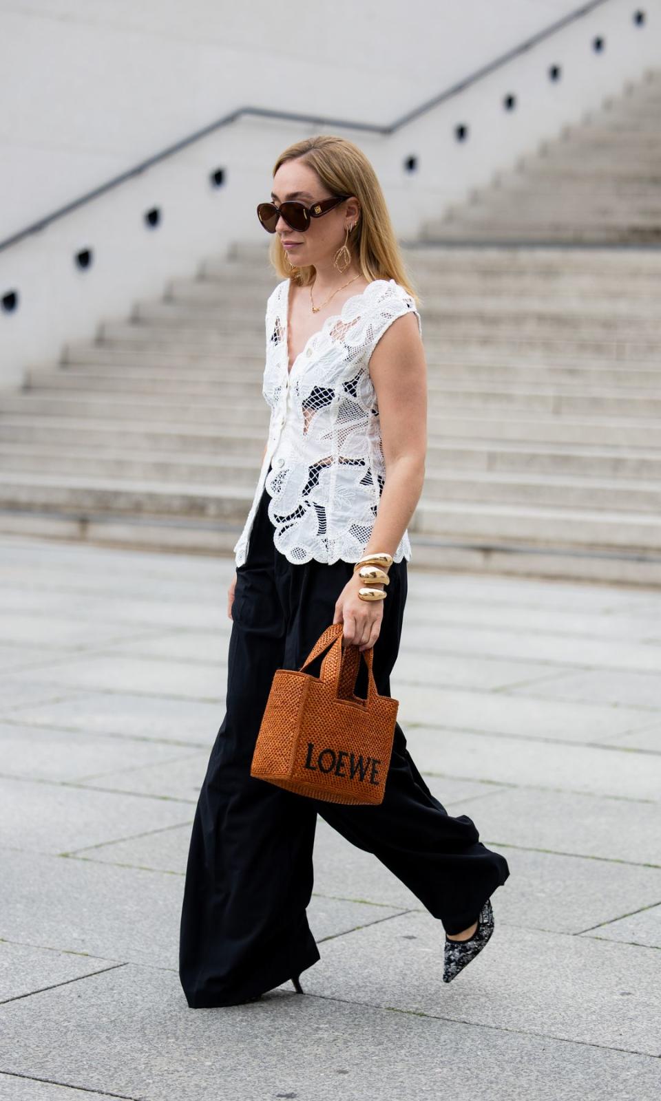 Pantalón ancho negro, top sin mangas blanco, bolso marrón Loewe