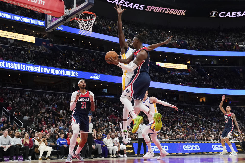 Washington Wizards guard Delon Wright passes the ball as Golden State Warriors forward Draymond Green defends during the first half of an NBA basketball game, Monday, Jan. 16, 2023, in Washington. (AP Photo/Jess Rapfogel)