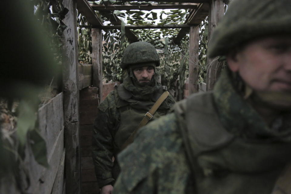 FILE - Servicemen walk in a trench at the line of separation near Yasynuvata, about 15 km north of Donetsk, controlled by Russia-backed separatists, eastern Ukraine, Dec. 14, 2021. Amid fears of a Russian invasion of Ukraine, tensions have also soared in the country’s east, where Ukrainian forces are locked in a nearly eight-year conflict with Russia-backed separatists. A sharp increase in skirmishes on Thursday raised fears that Moscow could use the situation as a pretext for an incursion. (AP Photo/Alexei Alexandrov, File)