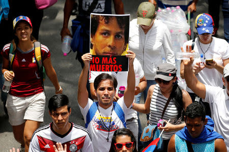 A demonstrator holds a picture as he takes part in a rally to honour victims of violence during a protest against Venezuela's President Nicolas Maduro's government in Caracas, Venezuela, April 22, 2017. Picture reads, "No more deaths". REUTERS/Carlos Garcia Rawlins