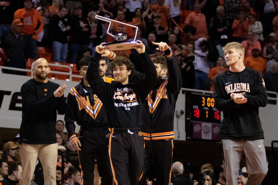 OSU wrestler Daton Fix holds up the Bedlam series trophy after beating OU on Feb. 20, 2022.