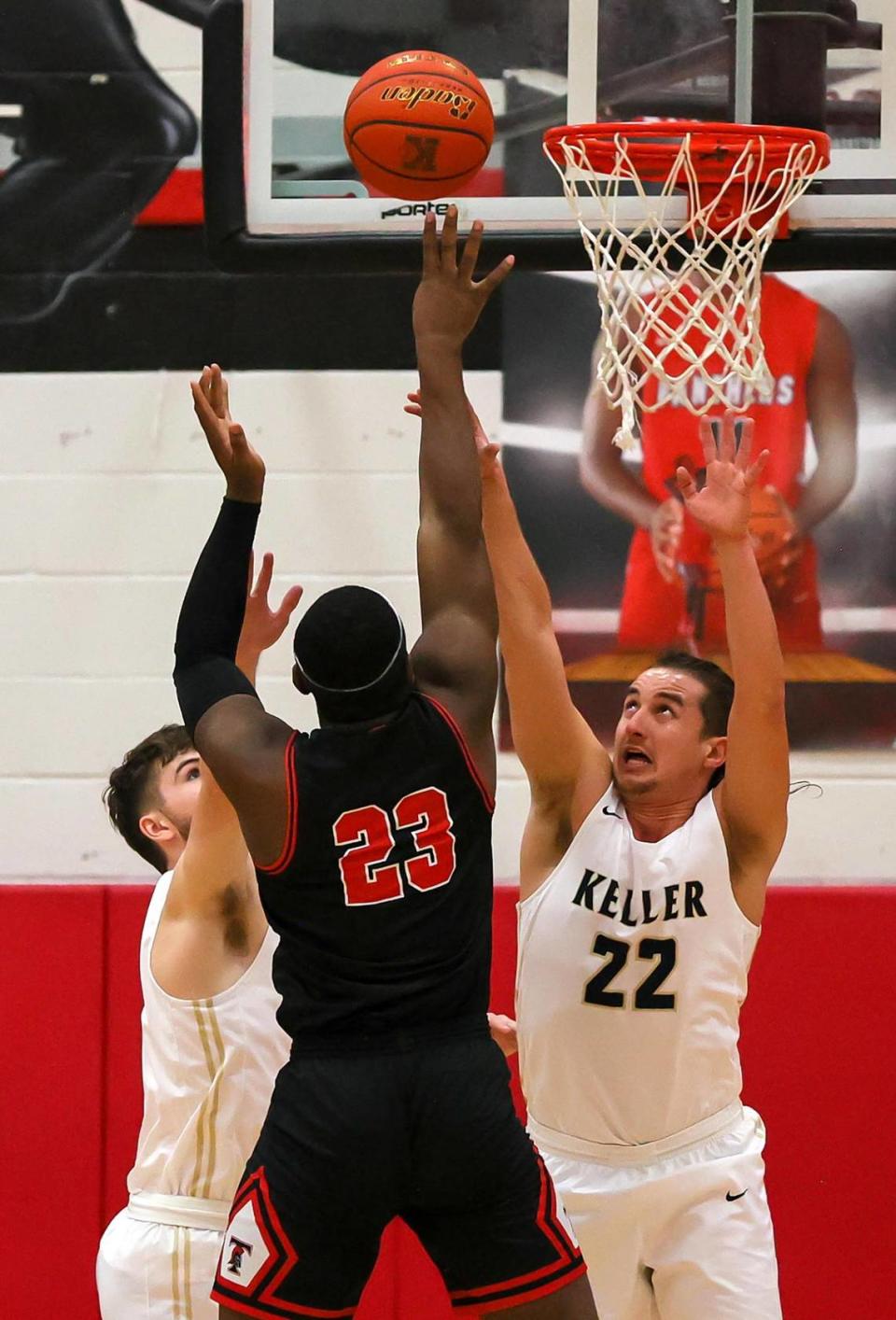 Trinity forward Noel Kabanga (23) shoots over Keller forward Cole Roberts (22) and forward Luke Bowen (L) during the first half of a 6A Bi-District High School Basketball playoff game played Monday, February 22, 2021 at Colleyville Heritage High School. (Steve Nurenberg Special to the Star-Telegram)