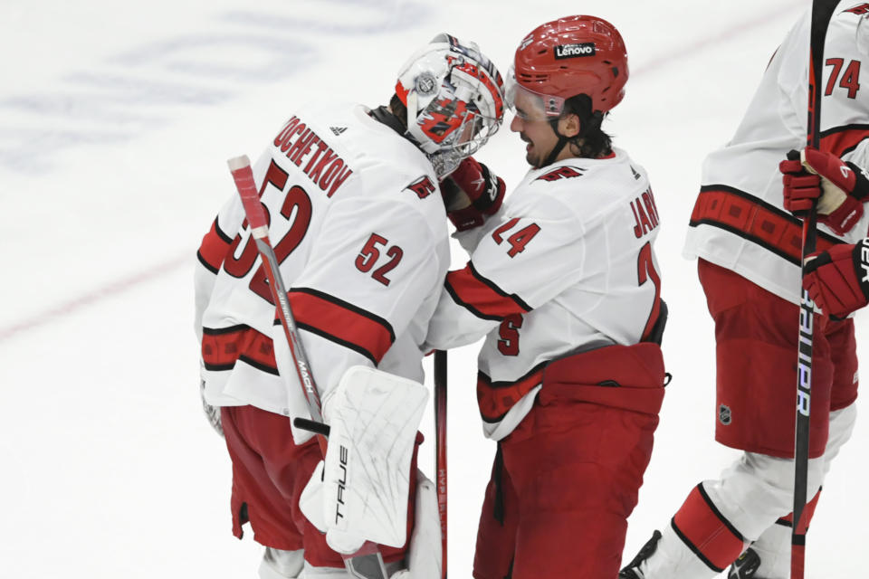 Carolina Hurricanes goalie Pyotr Kochetkov (52) celebrates with teammate Seth Jarvis (24) after defeating the Chicago Blackhawks in an NHL hockey game Sunday, April 14, 2024, in Chicago. (AP Photo/Paul Beaty)