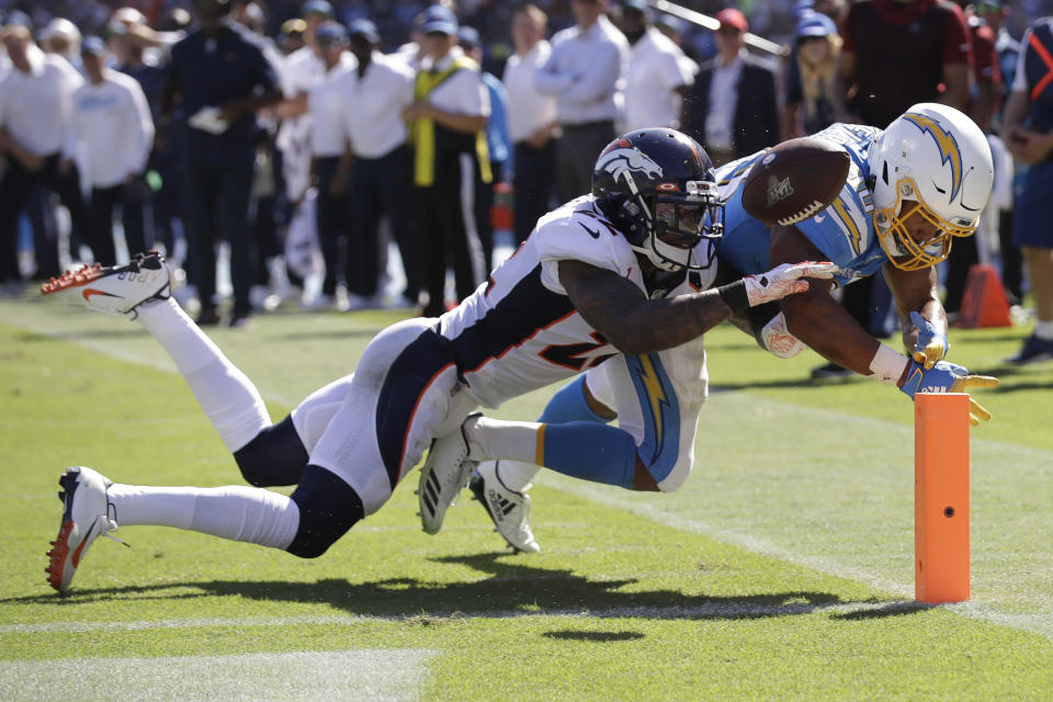 Denver Broncos defensive back Kareem Jackson, left, forces a fumble by Los Angeles Chargers running back Austin Ekeler at the goal line during the first half of an NFL football game Sunday, Oct. 6, 2019, in Carson, Calif. (AP Photo/Marcio Jose Sanchez)