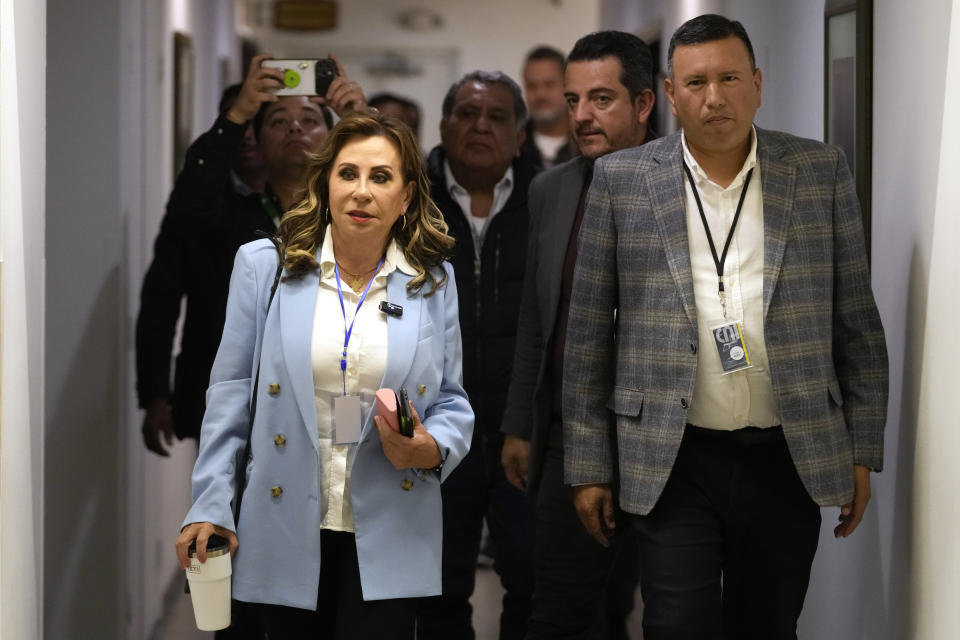 Sandra Torres, left, presidential candidate with the National Unity of Hope party (UNE), accompanied by her running mate Romeo Guerra arrives for a press conference in Guatemala City, Monday, June 26, 2023. Preliminary and partial results in Guatemala's presidential election pointed early on Monday to the likelihood of a second round of voting. (AP Photo/Moises Castillo)