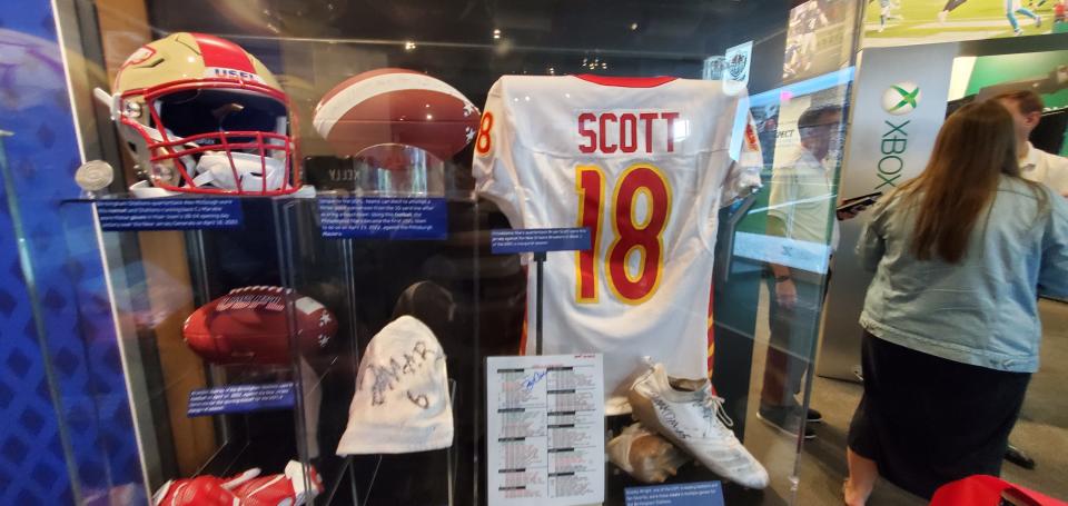 USFL exhibit displays artifacts of current USFL players including a jersey of Philadelphia Stars quarterback Bryan Scott, Birmingham Stallions' linebacker Scooby Wright's cleats and Stars head coach Bart Andrus's playsheet.