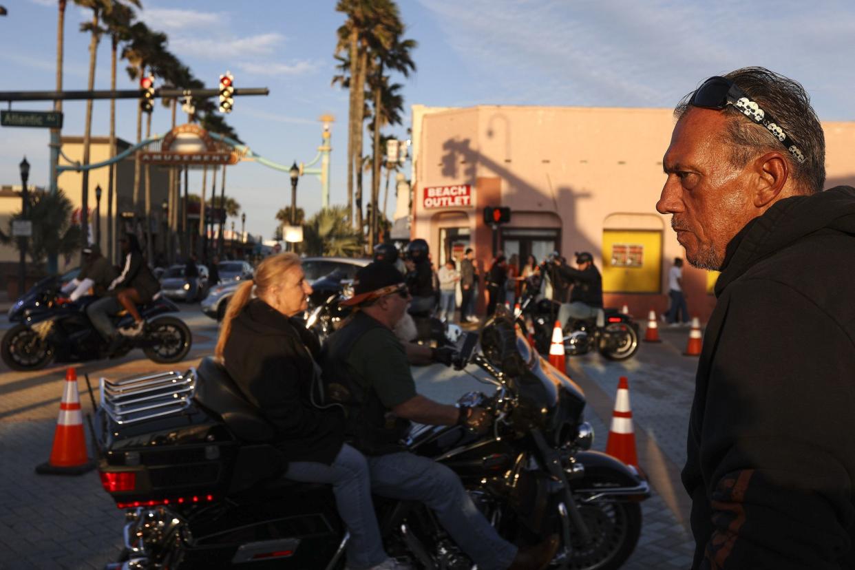 A man watches bikers ride past in Daytona, FL during the starting day of Bike Week on March 5, 2021. (Sam Thomas/Orlando Sentinel)