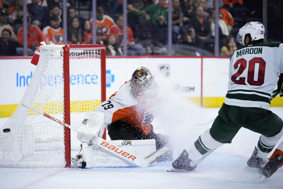 Philadelphia Flyers' Carter Hart, left, blocks a shot as Minnesota Wild's Pat Maroon skates in during the third period of an NHL hockey game, Thursday, Oct. 26, 2023, in Philadelphia. (AP Photo/Matt Slocum)